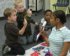 Image: Seventh grader Lynicia Maynard assists younger students Skyler Withrow and Freddie Scott in a math game question.