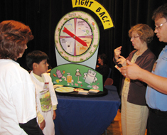 Image: USDA food scientist discusses food safety quiz questions with KDES student.