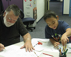 Image: KDES student Alyssa Biega works alongside Chuck Baird on a De’VIA  artwork project.