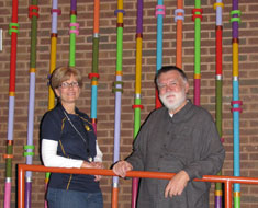 Image: KDES principal Nancy Berrigan stands with Chuck Baird in front of the art installation Baird created which will be mounted on the walls of the KDES auditorium.
