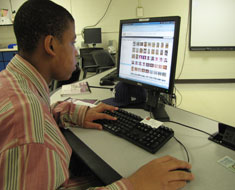 Image: Marcus Pointer, sports copy editor for the KDES yearbook, reviews captions for basketball photos.