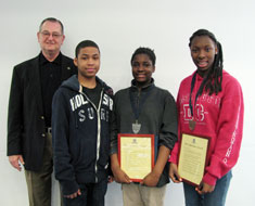 Image: Optimist Club contest sponsor Stephen Toth (far left) poses with KDES students Juwan Blackwell, Shannon Thornhill,and Malita Bailey, who won first, second, and third place respectively in the 13-18 age category.