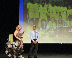 Image: At the KDES Recognition Day Ceremony held on June 8, mistress and master of ceremonies Katherine Rickey and Ju’wan Blackwell stand in front of a photo of the KDES Tri-State champions.