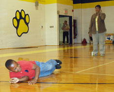Image: Student Keonte Marshall demonstrates “Stop, Drop, and Roll” while Patricia Everett from the D.C. Fire Department observes.