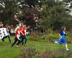 Image: Alice runs away from a pack of cards in the House One garden.