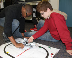 Image: Students Emmanuel Njoku and Matt Thompson test out their LEGO robot on a game board. (All photos: Susan Flanigan)
