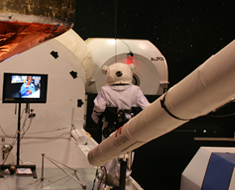 Image: Suited up in astronaut gear, a student follows instructions from MSSD Mission Control manager Mikail Baptiste for repair to the outside of the simulated space shuttle.