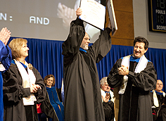 Image: Commencement speaker Gary Malkowski proudly displays his honorary doctor of humane letters degree while Board of Trustees member Nancy Kelly-Jones and Board Vice Chair Dr. Harvey Goodstein look on.  -Photo courtesy Enrollment Marketing.
