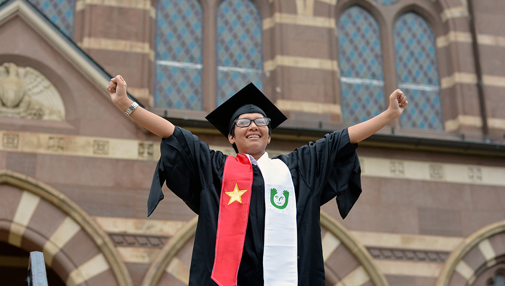 Online Degree Completion Program A graduate in front of Chapel Hall