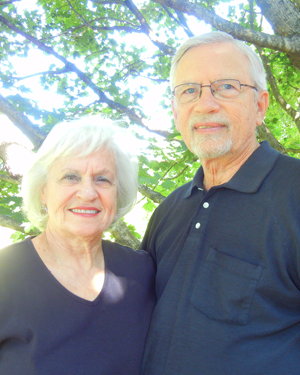 Ronald and Melvia Nomeland in dark shirts outside under a tree.