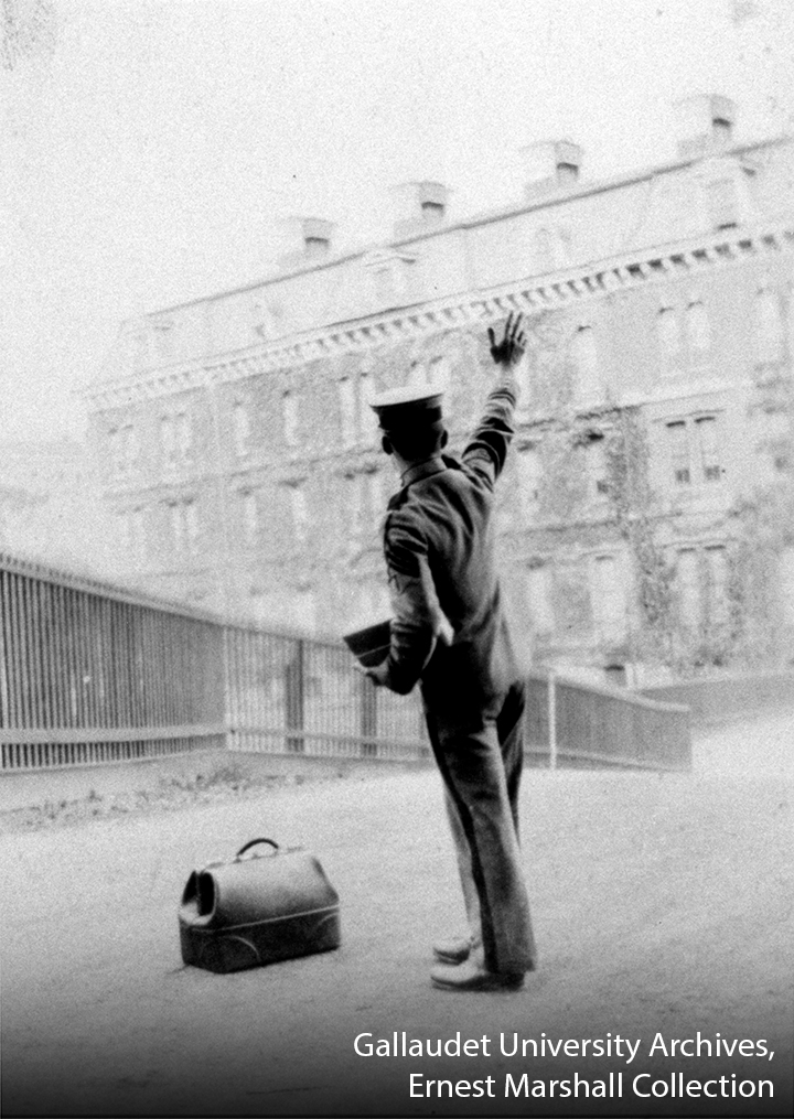 Ernest Marshall with the bag on the ground as he waved good-bye towards Fanwood School building.