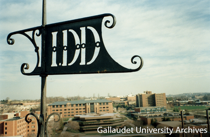 Close up photo of "IDD" weathervane on top of Chapel Hall overlooking over the west side of Gallaudet campus.
