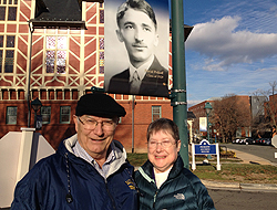 Pauline and David Peikoff's daughter Joyce poses in front of Peifkoff's lightpole banner with her husband Dr. Richard Meisegeier.