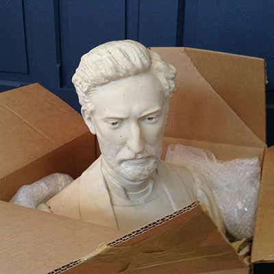 A sculptured bust lies in an opened box.