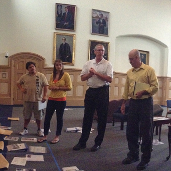 Group of people go over exhibit materials at the exhibit retreat.