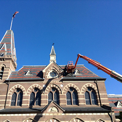 A crane with workers repairing the roof at Chapel Hall