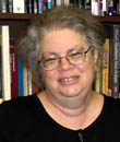 Sharon Barnartt sits in front of a bookshelf.